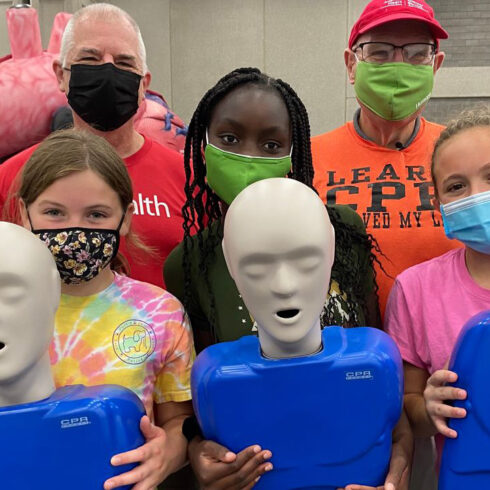 Greg Brislin leads group of children/students in CPR training