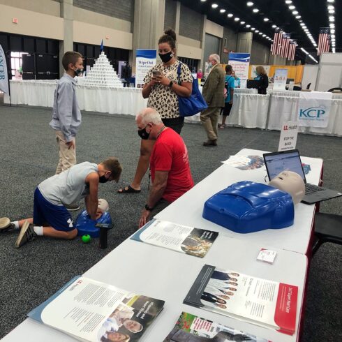 Greg Brislin oversees student providing chest compressions to CPR dummy